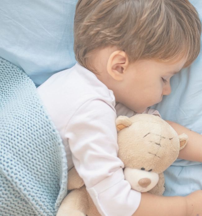 Toddler asleep with a teddy bear